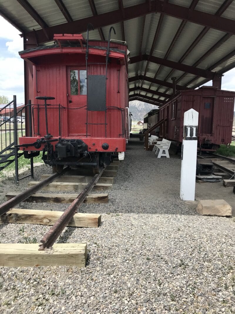 A red train car sits at rest beneath an awning.